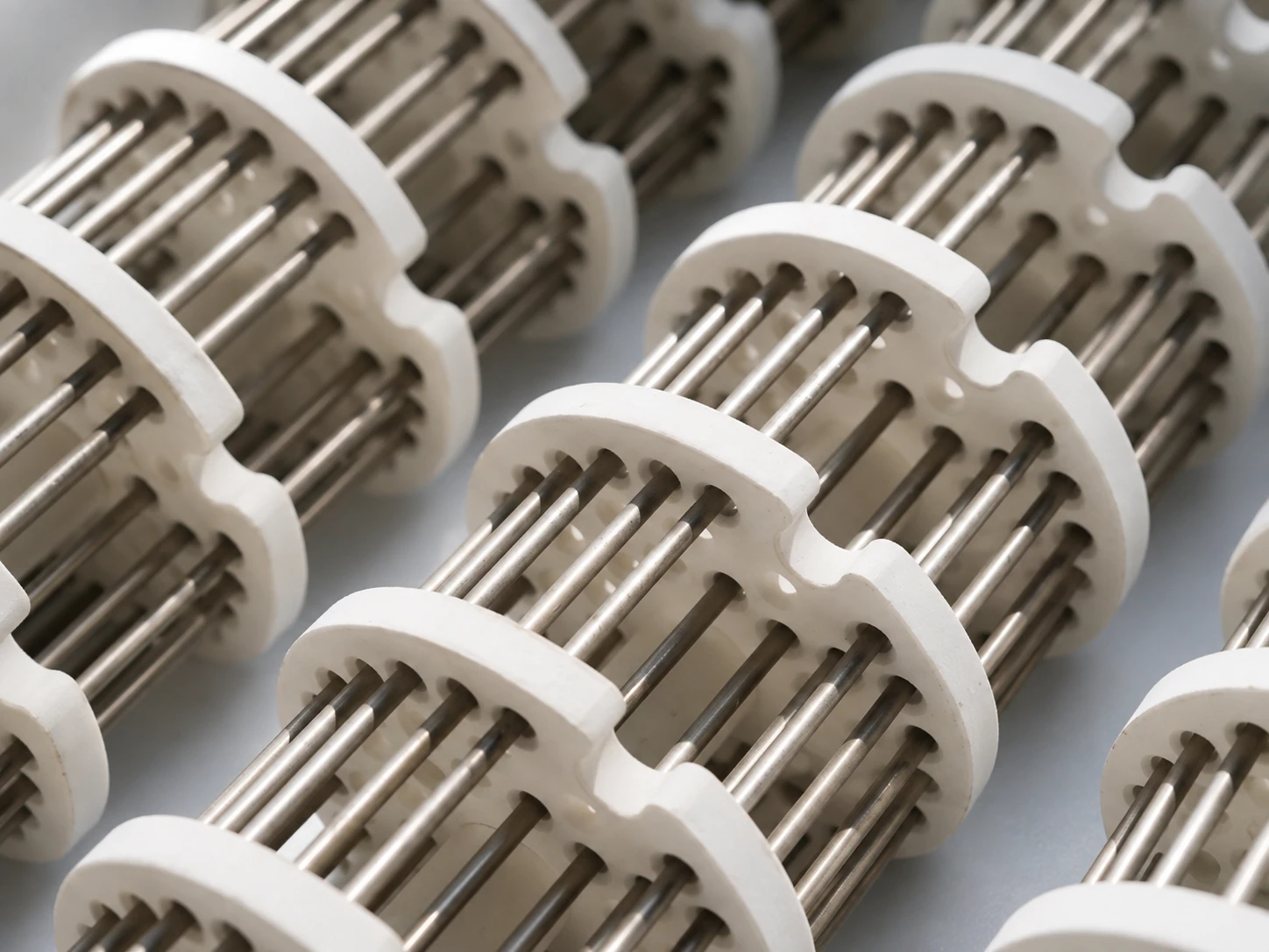 Electric radiant tube heater structure with ceramic spacers and metal rods